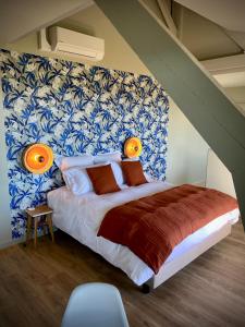 een slaapkamer met een bed met blauw en wit behang bij La Bellevue Bistrot et Chambres d'Hotes in Séné