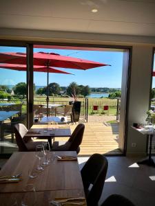 restauracja ze stołami i krzesłami z widokiem na patio w obiekcie La Bellevue Bistrot et Chambres d'Hotes w mieście Séné +37 zdjęć