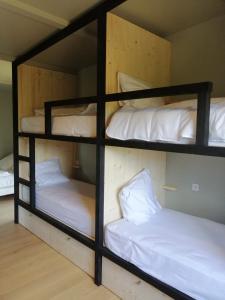 two bunk beds in a room with white pillows at La Maison dans l'Airial, maison d'architecte en pleine nature, PISCINE in Onesse-et-Laharie