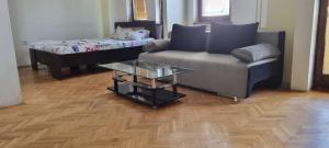 a living room with a couch and a coffee table at Nakov Apartment next to bus station in Skopje