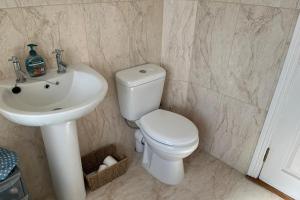 a bathroom with a white toilet and a sink at Achill Sound Holiday Village No 11 in Achill Sound