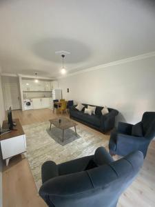 a living room with two blue couches and a table at homeland residans in Tokat