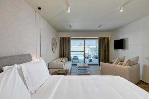 ティガキにあるUtopia Blu Hotelのベッドとリビングルームが備わるホテルルームです。