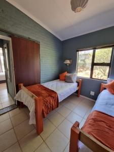 a bedroom with two beds and a window at Abaloo Apartment #1 in Sabie
