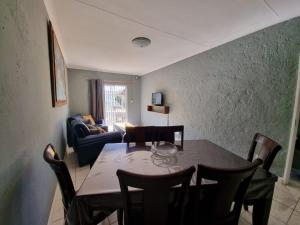 a dining room with a table and chairs and a couch at Abaloo Apartment #1 in Sabie