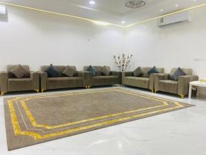 a living room with two couches and a rug at شالية الفضائل in Barka