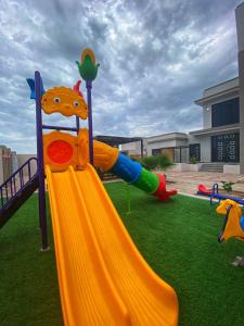 a playground with a slide in the grass at شالية الفضائل in Barka