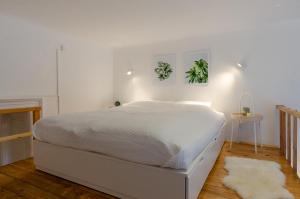 1 cama blanca en un dormitorio con una pared blanca en COSY APARTMENT IN CENTRAL DISTRICT., en Budapest