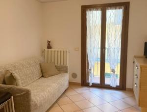 - un salon avec un canapé et une porte coulissante en verre dans l'établissement Lovely apartment in center of Barzio, à Barzio