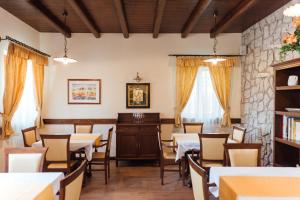 a dining room with tables and chairs and a stone wall at Hotel & Restaurant Pahor in Doberdò del Lago