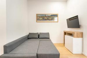 a large bed in a white room with a flat screen tv at Testaccino Case vacanze in Rome