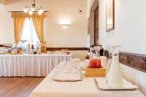 a table with glasses and bottles and a table with a buffet at Hotel & Restaurant Pahor in Doberdò del Lago