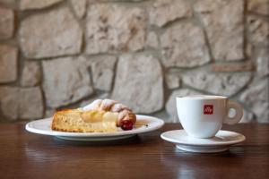 a piece of cake and a cup of coffee on a table at Hotel & Restaurant Pahor in Doberdò del Lago