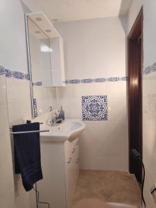 a white bathroom with a sink and a mirror at Aeolian Sea House in Santa Marina Salina