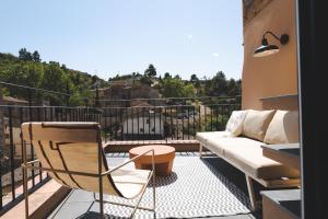 einen Balkon mit einem Sofa und einem Tisch in der Unterkunft ORA Hotel Priorat, a Member of Design Hotels in Torroja