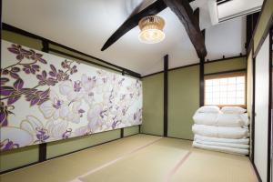 a room with green walls and a wall with towels at Kanade Fushimiinari in Momoyama-chō