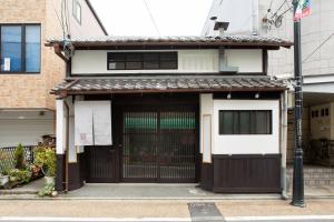 a house with a black gate and a building at Kanade Fushimiinari in Momoyama-chō