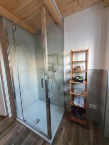 La salle de bains est pourvue d'une douche avec une porte en verre. dans l'établissement Casina Elena - Viareggio centro, à Viareggio