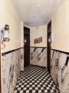 un corridoio con pavimento a scacchi in bianco e nero di Hotel Majestic a Calcutta