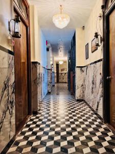 a hallway with a black and white checkered floor at Hotel Majestic in Kolkata
