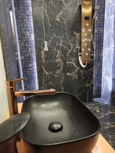 - czarną umywalkę w łazience z prysznicem w obiekcie APARTAMENT NAD JEZIOREM w Sławie