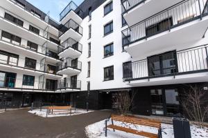 a building with two benches in front of it at Project Comfort Apartament Potrzebna 55/130 Warszawa in Warsaw