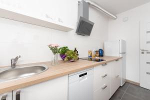 a kitchen with white cabinets and a sink at Project Comfort Apartament Potrzebna 55/130 Warszawa in Warsaw