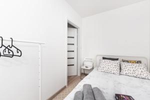 a white bedroom with a bed and a mirror at Project Comfort Apartament Potrzebna 55/130 Warszawa in Warsaw