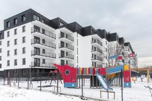 a playground in front of a apartment building at Project Comfort Apartament Potrzebna 55/130 Warszawa in Warsaw