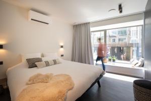 um quarto com uma cama e uma grande janela em Georges & Madeleine Apartments em Aalst