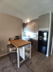 cocina con mesa de madera y nevera negra en Apartamento D´Ousseau, en Jaca