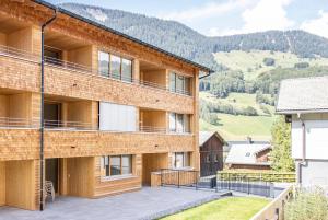 um edifício de apartamentos com uma varanda com montanhas ao fundo em Huus123 em Au im Bregenzerwald