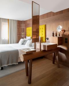 a bedroom with a bed and a mirror and a sink at Coeur de Megève in Megève