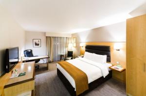 una camera d'albergo con un grande letto e una scrivania di Holiday Inn London Brentford Lock, an IHG Hotel a Brentford