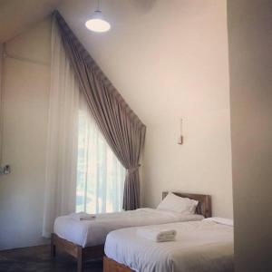 two beds in a room with a window at Promma Farm Resort in Ban Tat Ton (1)