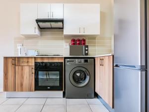 a kitchen with a washer and a dishwasher at Green Park Haven 1 in Pretoria +2 photos