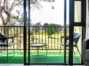 a room with a balcony with a table and chairs at Green Park Haven 1 in Pretoria