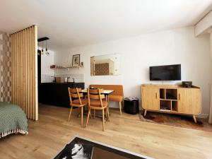 a living room with a table and chairs and a kitchen at Deauville centre et mer in Deauville