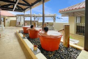 dos hombres están sentados en bañeras en un resort en Senagajima Island Resort & Spa, en Tomigusuku