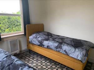 a bedroom with two beds and a window at Boerderij woning in Aalten in de Achterhoek in Aalten