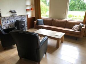 a living room with a couch and a coffee table at Boerderij woning in Aalten in de Achterhoek in Aalten