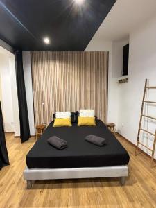 um quarto com uma cama grande e almofadas amarelas em Suite cocooning & spa em Béziers