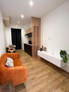 sala de estar con sofá naranja y mesa en Suite cocooning & spa en Béziers