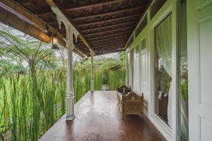 une terrasse couverte vide d'une maison avec de l'herbe dans l'établissement Rumah Jembarati, à Cangkringan