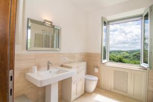 bagno con lavandino, finestra e servizi igienici di Casale Amerina a Camerata