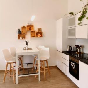 a kitchen with a white table and white chairs at CozyHome in Old Town, Presidential apartment in Bratislava