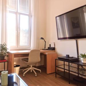 a room with a desk with a chair and a television at CozyHome in Old Town, Presidential apartment in Bratislava