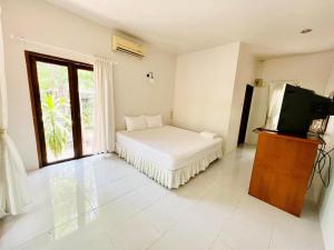 a bedroom with a bed and a tv and a window at Promma Farm Resort in Ban Tat Ton (1)