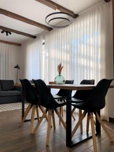 a dining room table with black chairs in a living room at Mulina River Lodge in Pribanjci