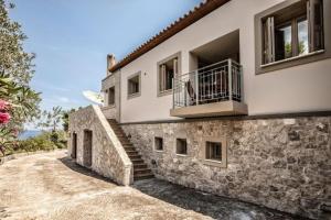 a stone house with a balcony and stairs at Rodia Eco stay house in Epidavros - Akros Estate in Nea Epidavros